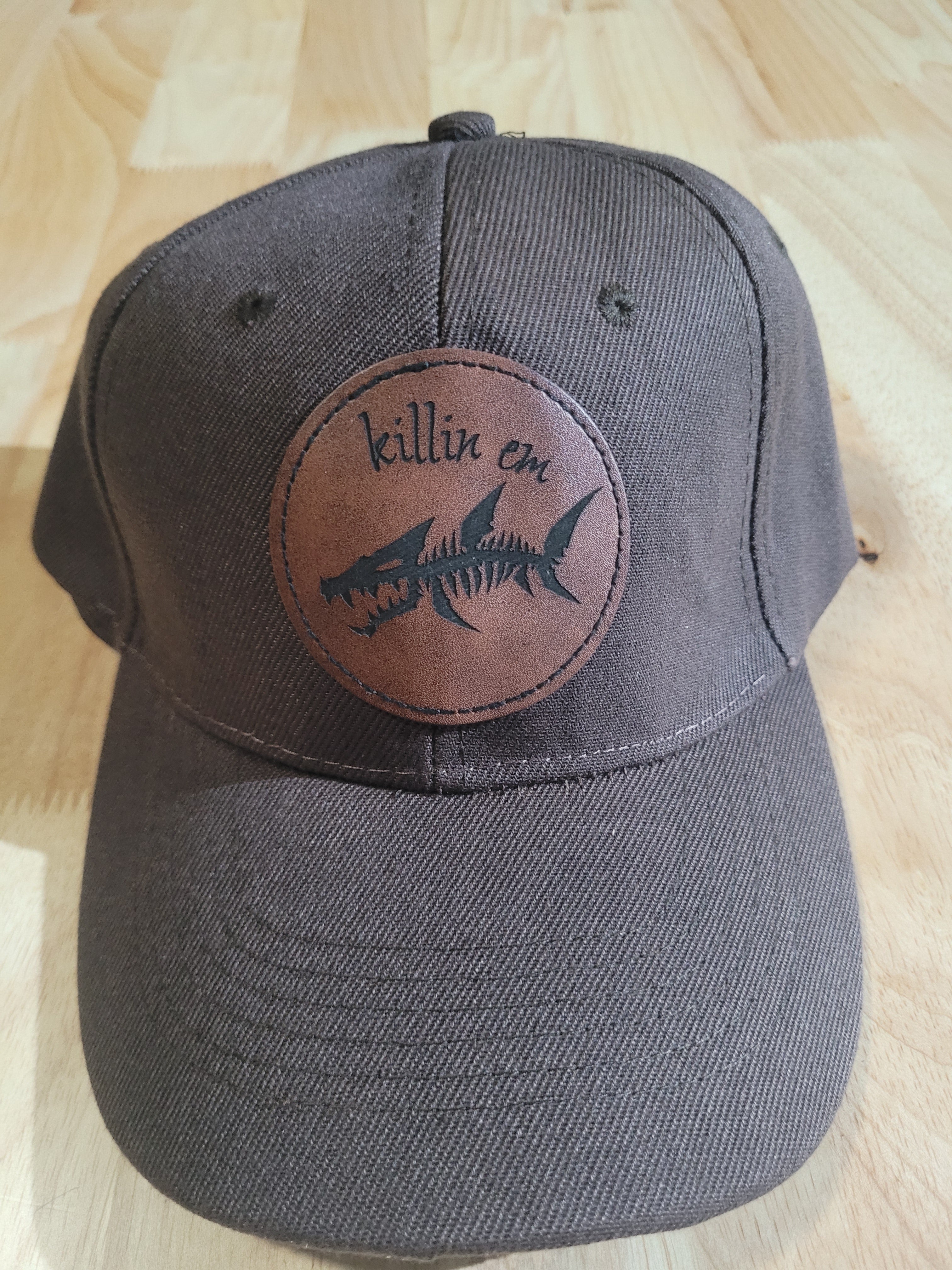 Brown Ball Cap with a fish skeleton patch saying "killin em"
