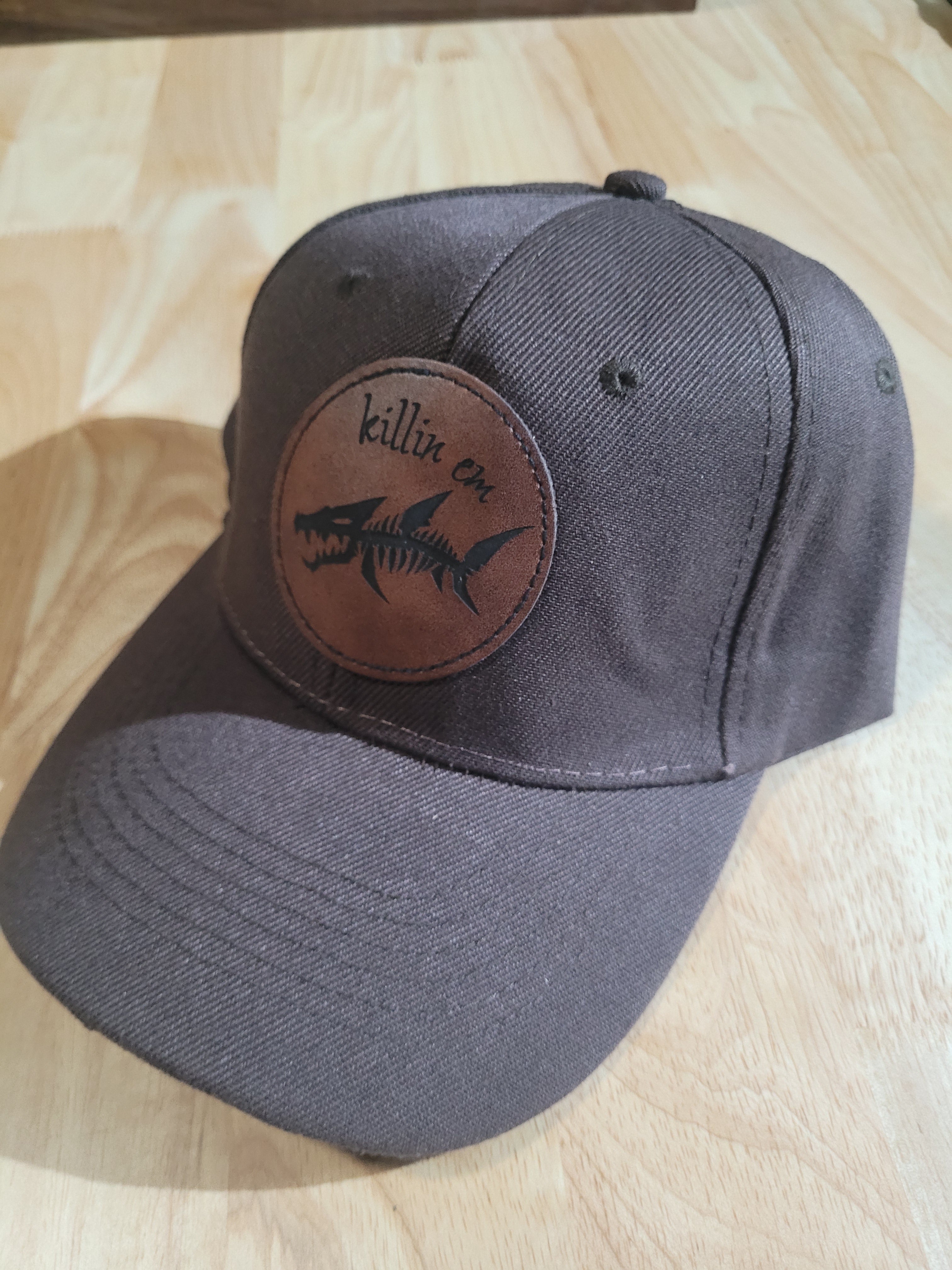 Brown Ball Cap with a fish skeleton patch saying "killin em"