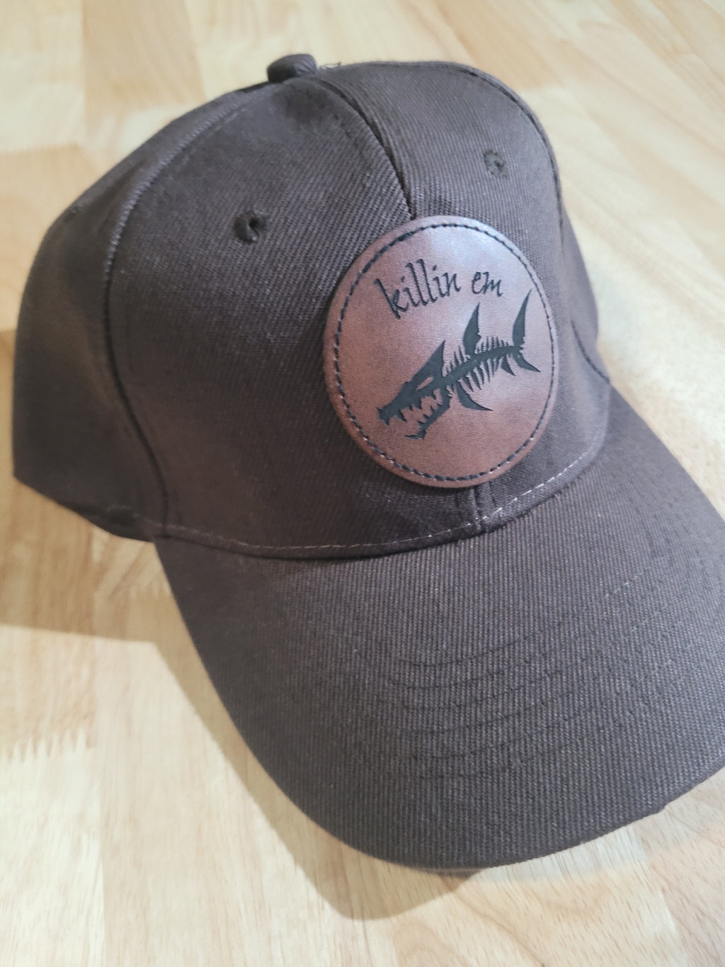 Brown Ball Cap with a fish skeleton patch saying "killin em"