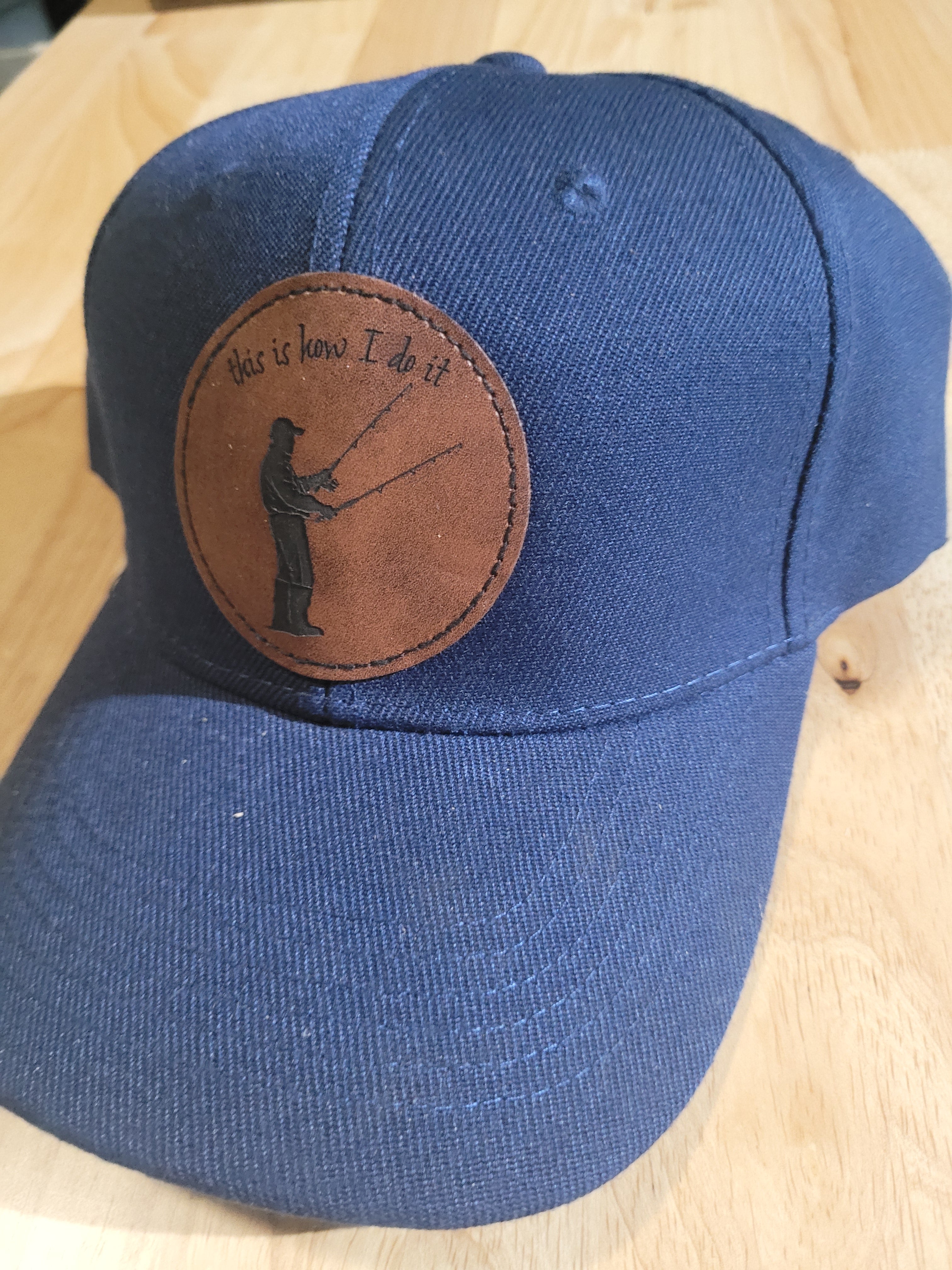 Blue Ball Cap with Patch of a Fisherman with two rods in his hands "This is How I do it"