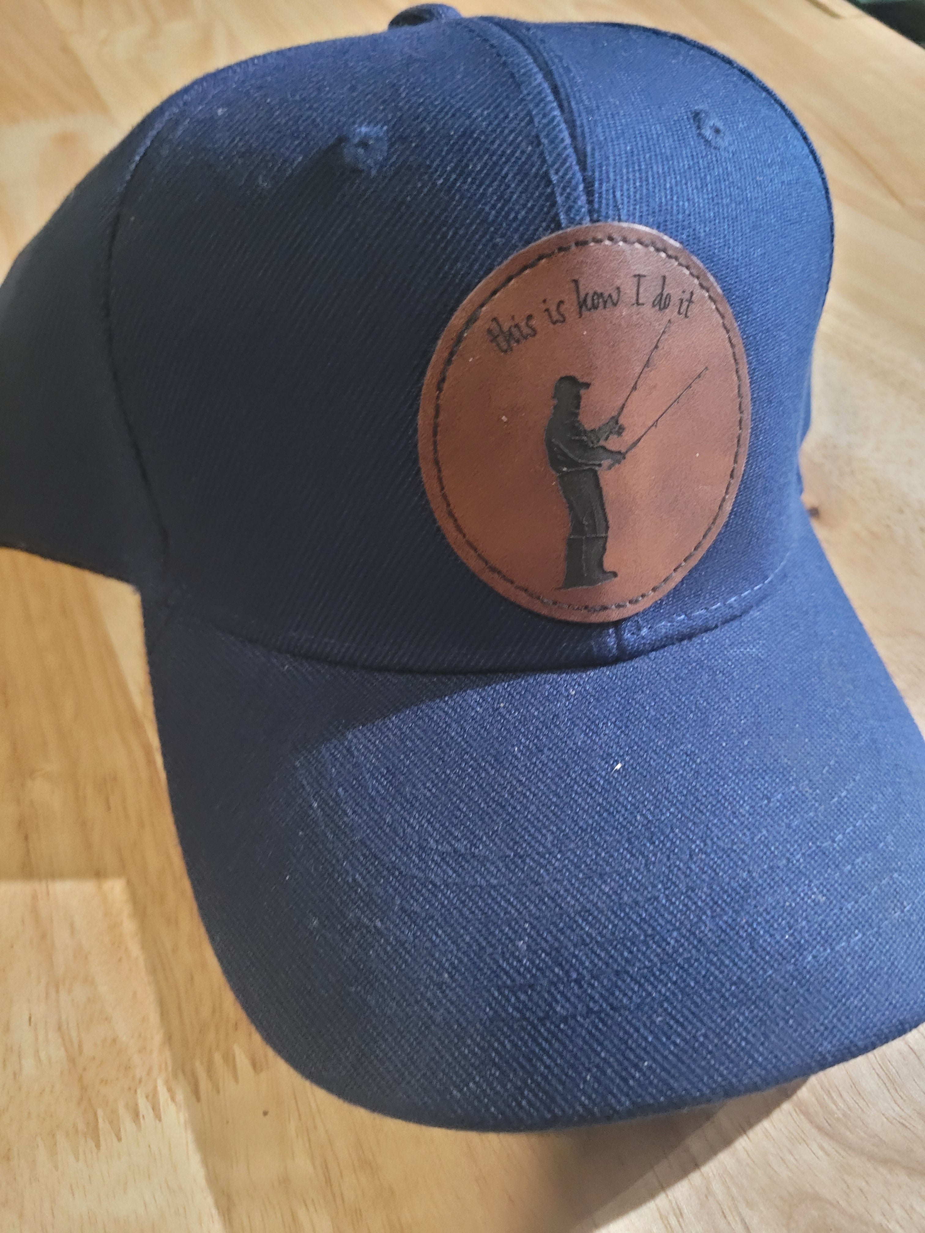 Blue Ball Cap with Patch of a Fisherman with two rods in his hands "This is How I do it"