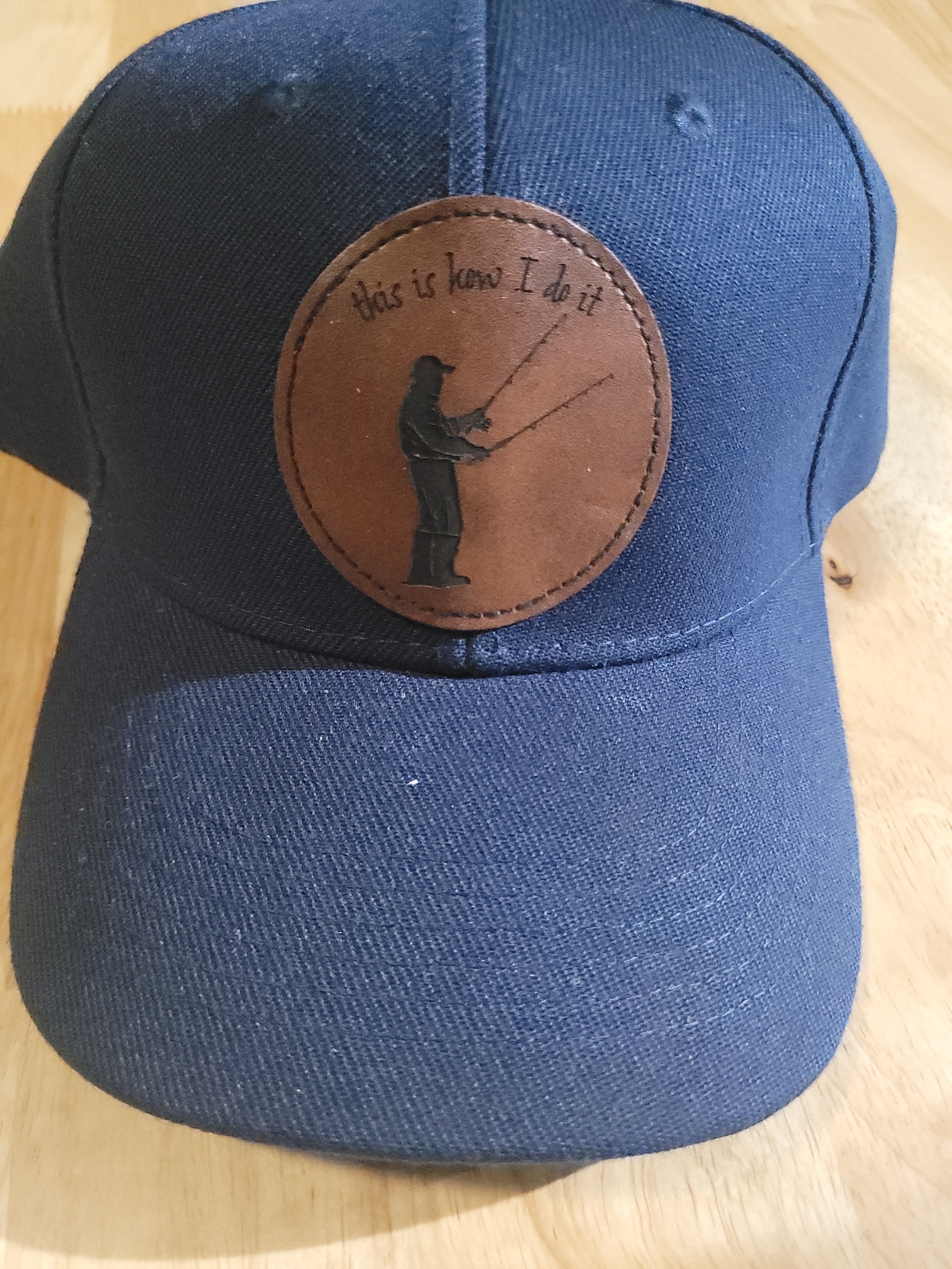 Blue Ball Cap with Patch of a Fisherman with two rods in his hands "This is How I do it"