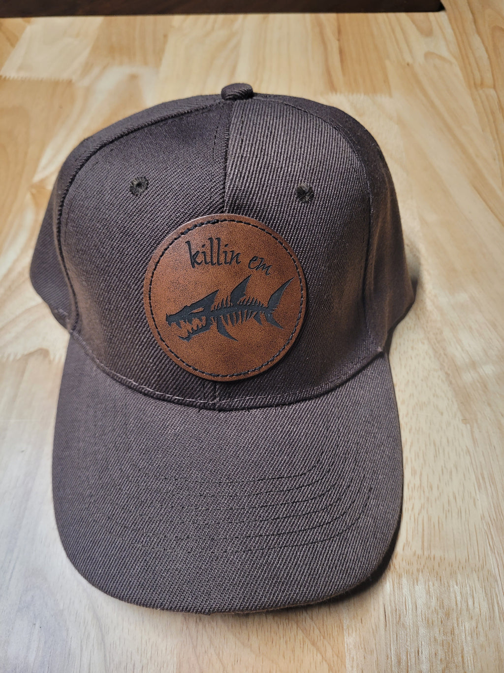 Brown Ball Cap with a fish skeleton patch saying "killin em"