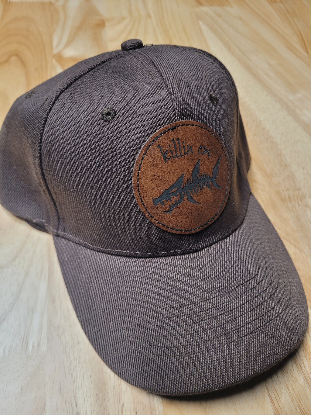 Brown Ball Cap with a fish skeleton patch saying "killin em"