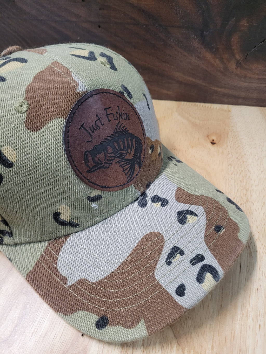 Desert Camo Ball Cap with an engraved fish skeleton patch saying "Just Fishin"